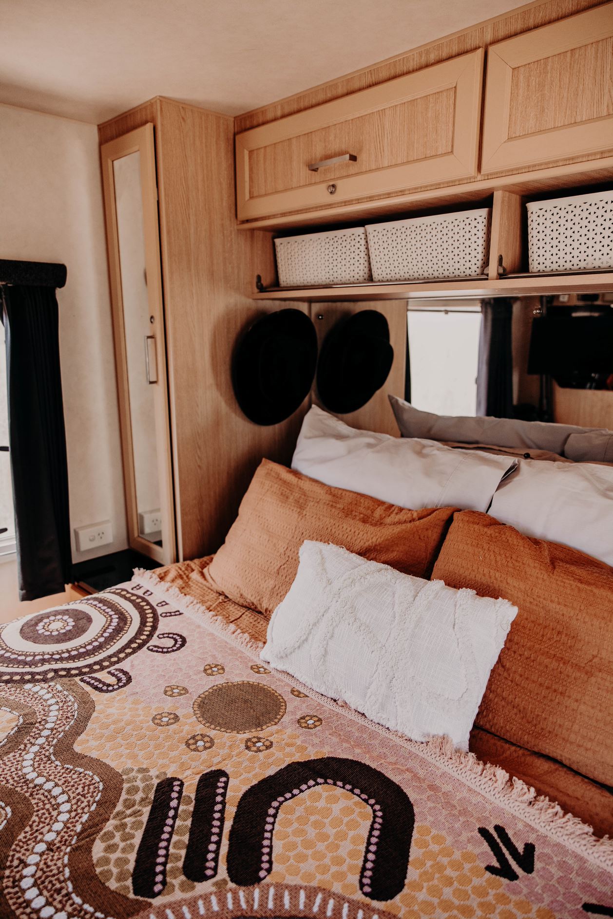 Coming Home Indigenous First Nations art throw rug over bed in caravan. Woven from recycled fabrics. First Nations art, Kalkadoon mob designed in Australia