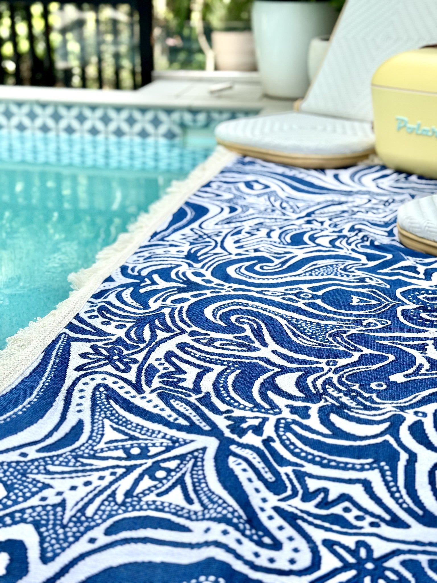 Blue Skies throw rug laying beside pool.