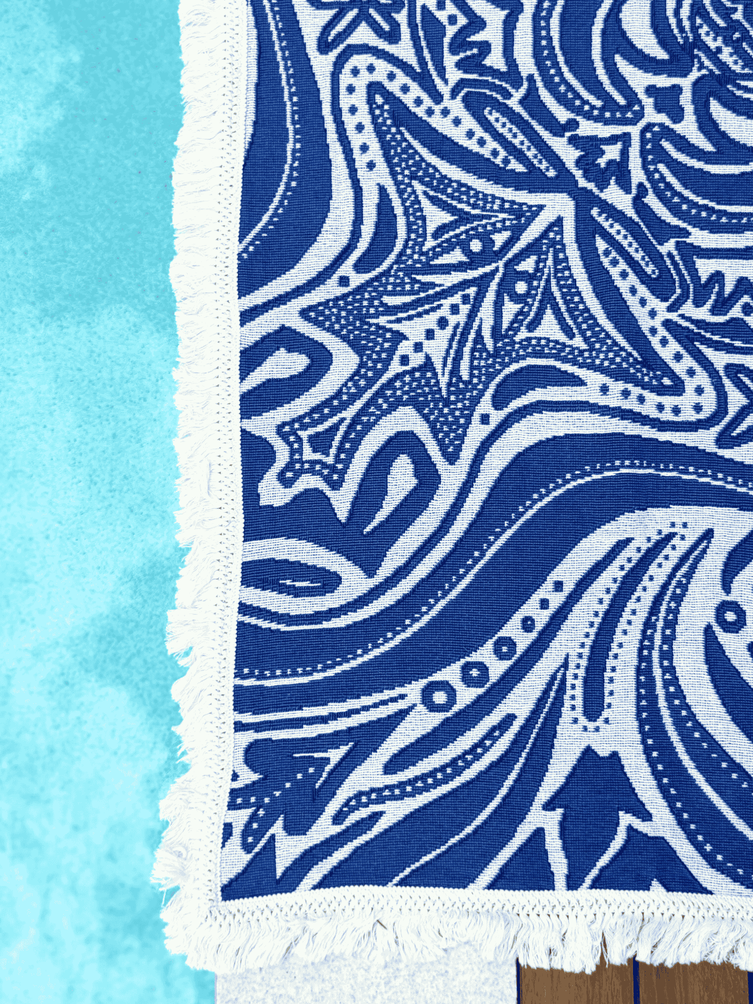 Blue Skies beach blanket or throw rug laying beside pool, showcasing the blue and white design created in Australia.