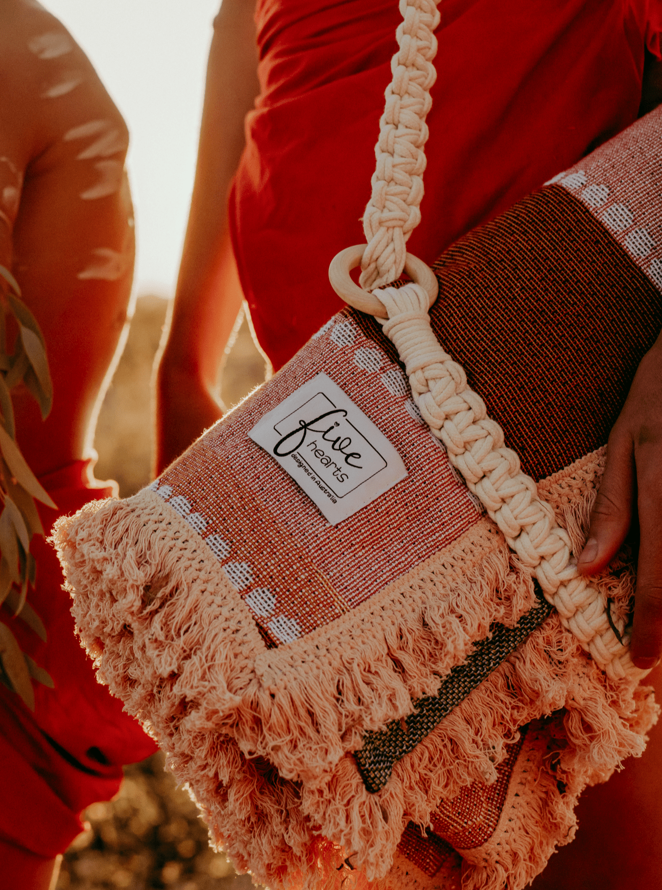 Macramé carry strap wrapped around Indigenous throw rug