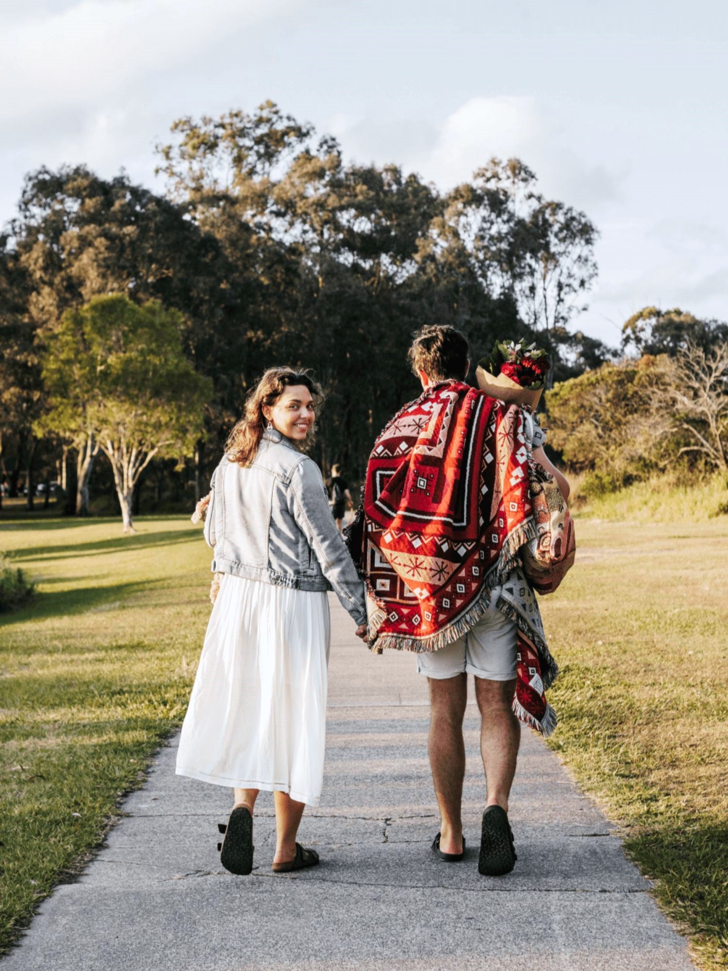 Couple on a picnic date with red picnic blanket / throw rug. Valentines picnic idea