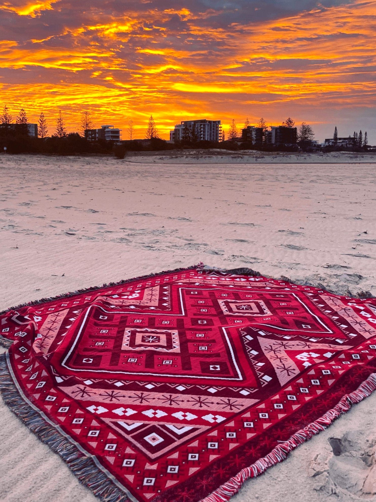 Red beach blanket / throw rug on Gold Coast beach watching sunset skies