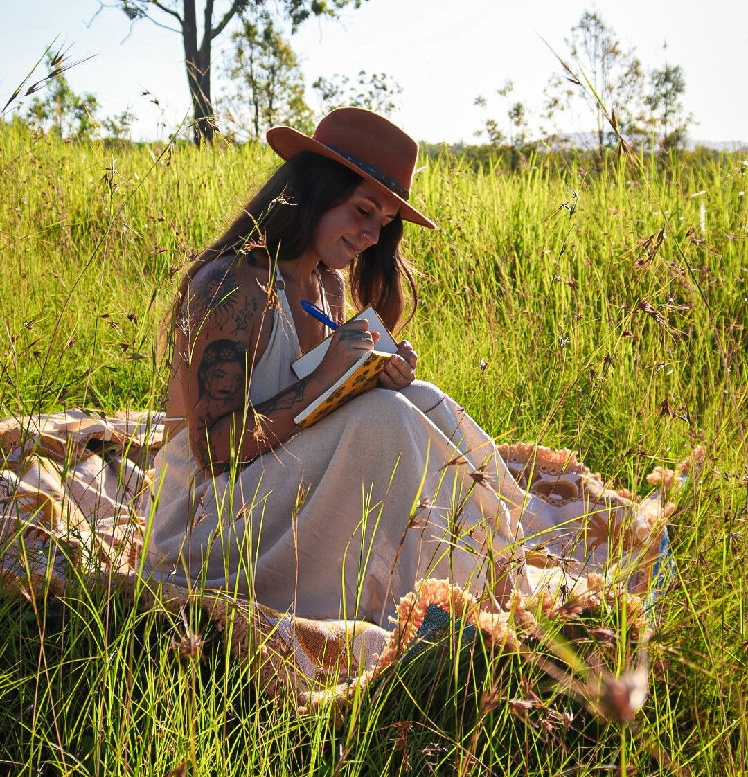 Self-care journaling outdoors on your Five Hearts palm throw rug