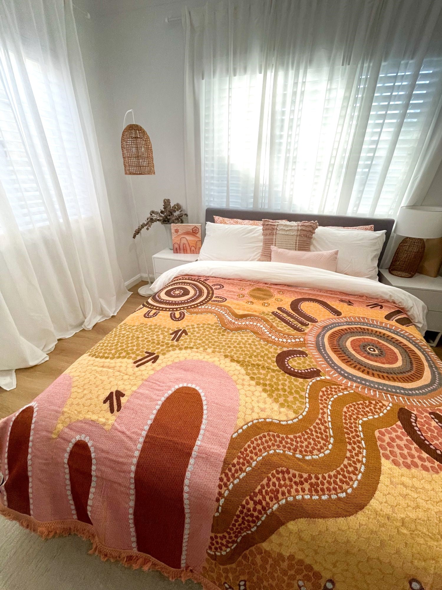 Coming Home Indigenous First Nations art throw rug over queen bed. Woven from recycled cotton. First Nations art, Kalkadoon mob designed in Australia